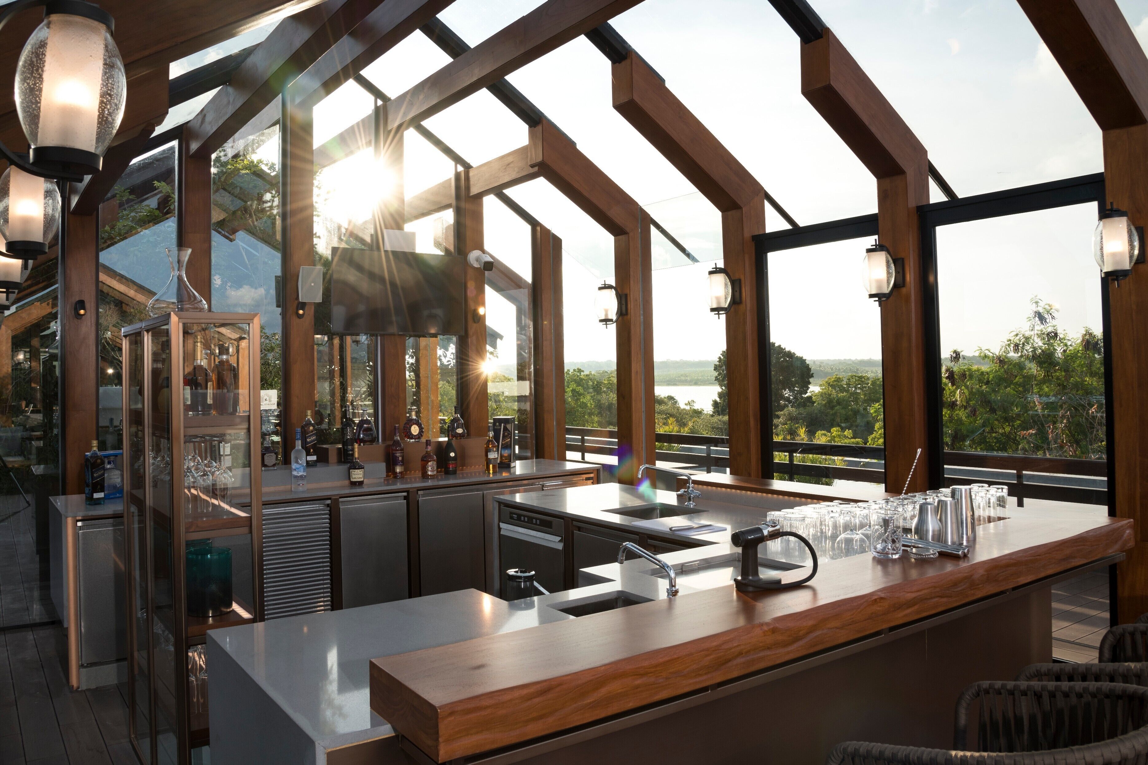 Una cocina moderna con barra, ventanas amplias y vistas al exterior.