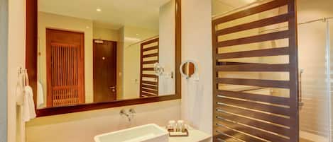 Une salle de bain moderne avec un grand miroir, un lavabo blanc et une cabine de douche en bois.