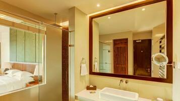 Un baño moderno con un espejo grande, un lavabo blanco y una zona de ducha.
