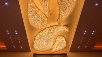 A ceiling with a decorative, illuminated design resembling a stylized bird or butterfly.
