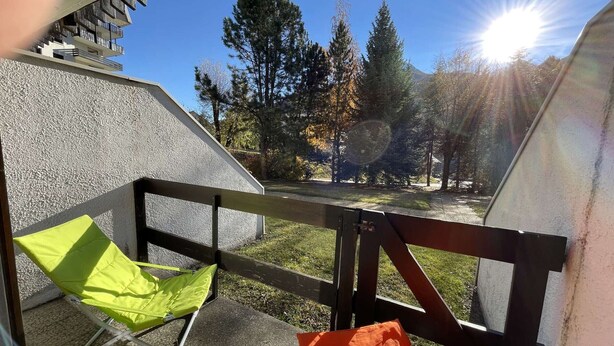 A balcony with a view of trees and a building in the background. - Cozy studio with mountain nook for 4 people in Chantemerle (Saint-Chaffrey)