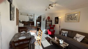 A compact living space with a dining area, kitchen, and a sofa. - Cozy studio with mountain nook for 4 people in Chantemerle (Saint-Chaffrey)