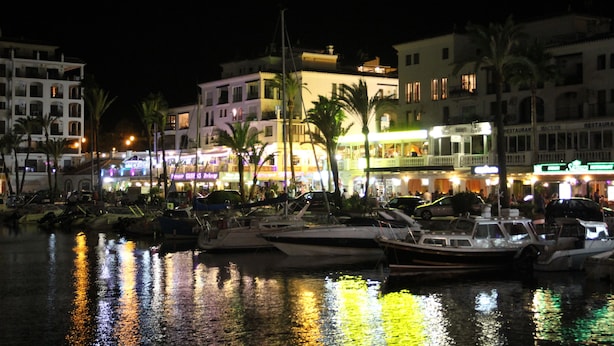 A marina with boats docked, a waterfront promenade with buildings, and palm trees. - Apartment cozy in quiet area near of beaches and shops (Manilva)