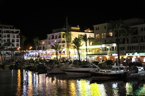 A marina with boats docked, a waterfront promenade with buildings, and palm trees. - Apartment cozy in quiet area near of beaches and shops (Manilva)