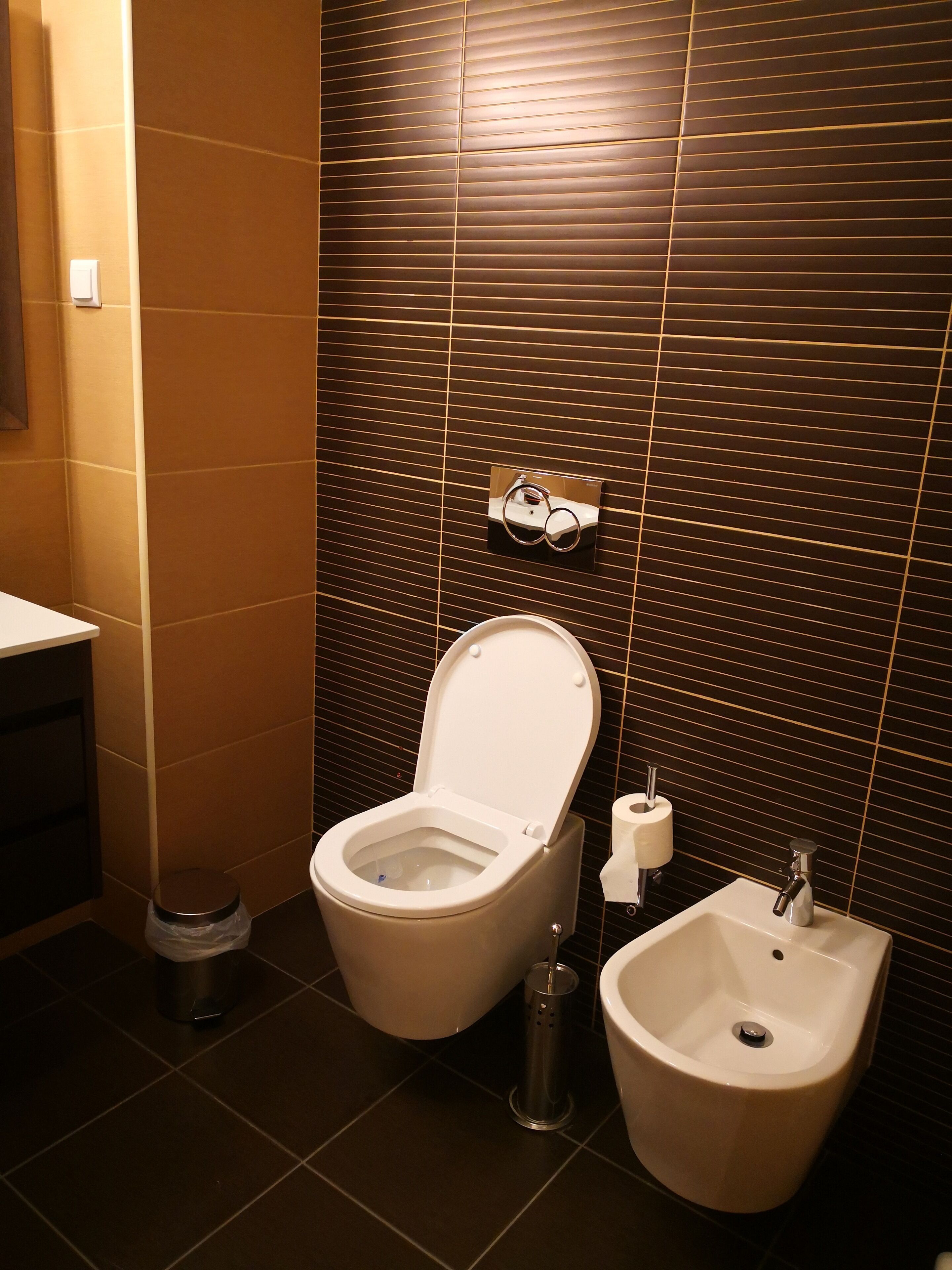 Un baño con inodoro, bidé y lavamanos.