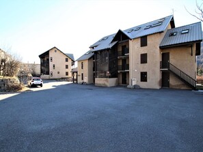 Un bâtiment comprenant plusieurs pièces, un espace de stationnement et un escalier menant à un étage supérieur.