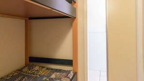 A bunk bed with a patterned bedspread and wooden headboard. - 2-Room Apartment - Sleeps 6, Near Prorel Lift and Briançon Center (Briançon)
