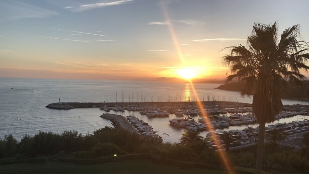 Un port de plaisance avec des bateaux amarrés au coucher du soleil.