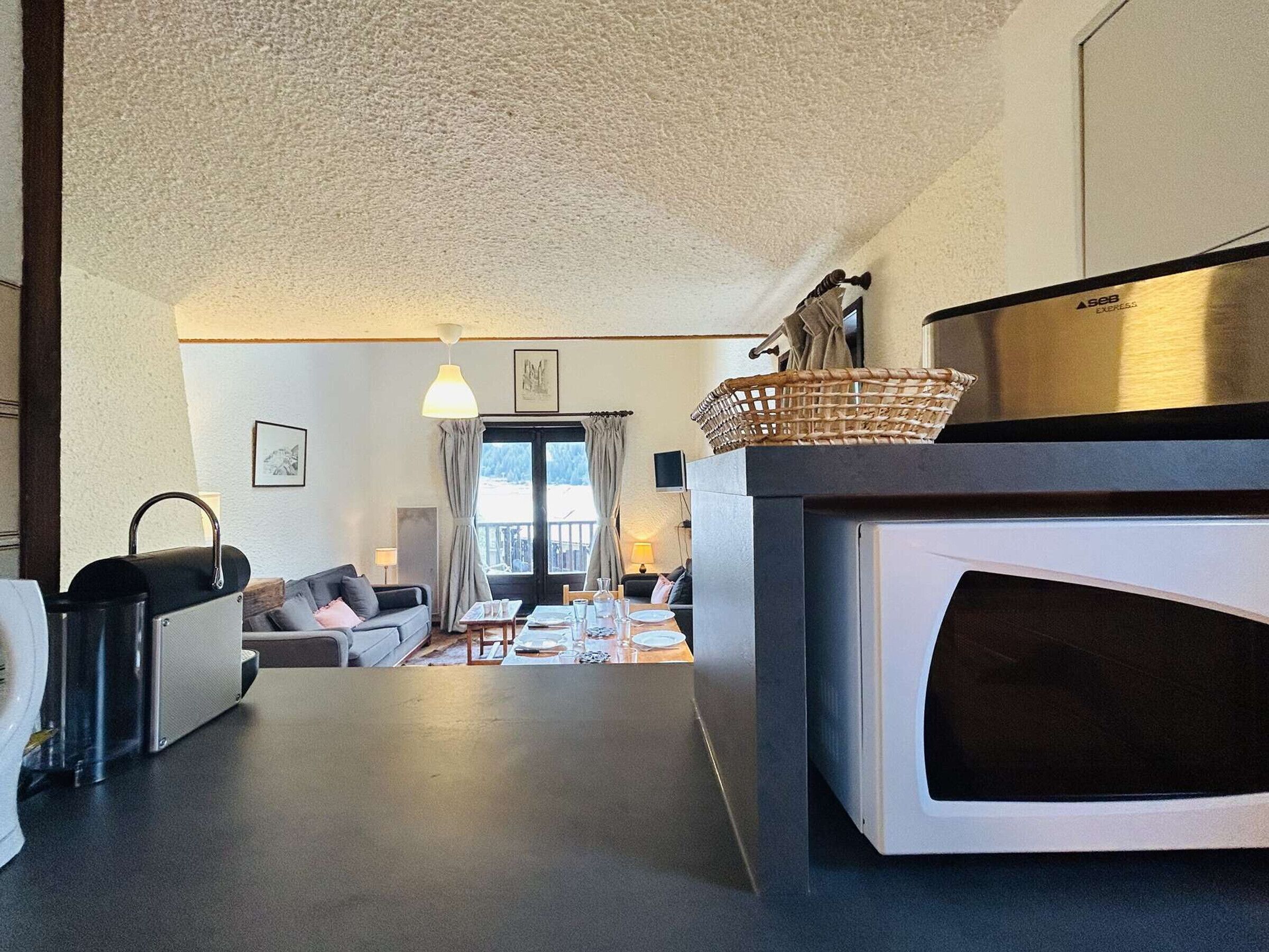 A compact living space with a kitchenette, a dining area, and a sofa.