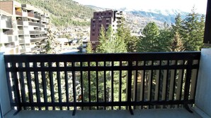 A balcony with a view of a mountainous landscape, buildings, and trees. - Charming Studio for 4 in Serre Chevalier, Close to Slopes & Shops (La Salle-les-Alpes)