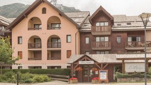 A hotel with multiple balconies, a sign for 'Pierre & Violette', and a sign for 'L'Alpaga'.