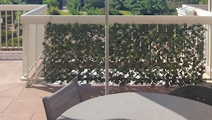 A patio with a round table and a turquoise umbrella. - Carnon Centre. Very nice apartment 50 m2 +terrace 25m2, sea and garden view (Mauguio)