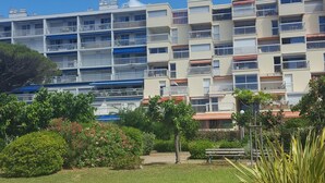 A multi-story residential building with balconies, surrounded by well-maintained grass and shrubs. - Carnon Centre. Very nice apartment 50 m2 +terrace 25m2, sea and garden view (Mauguio)