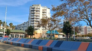 A modern high-rise building with multiple balconies, a parking lot with barriers, and a clear blue sky. - Carnon Centre. Very nice apartment 50 m2 +terrace 25m2, sea and garden view (Mauguio)
