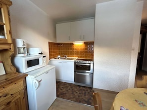 A compact kitchen with a microwave, coffee maker, sink, and oven. - Cozy Studio with Mountain Corner - 4 Sleeps, Near Slopes & Shops, La Salle Les Alpes (La Salle-les-Alpes)