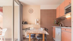 A compact kitchen with a dining table, chairs, and a small refrigerator. - Cozy studio 2/4 pers, Near Prorel lift and center (Briançon)