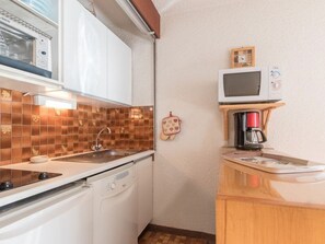 A compact kitchenette with a microwave, coffee maker, and a small oven.