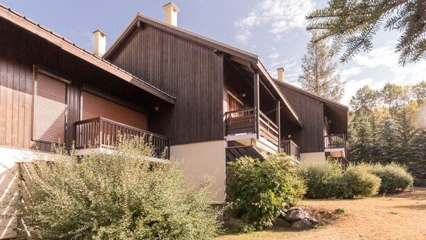 A two-story wooden building with balconies and a covered outdoor area. - Cozy mountain studio for 5 people in Chantemerle - Serres-Chevalier (Saint-Chaffrey)