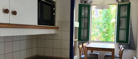 A compact kitchen with a microwave, dishwasher, and a small table with chairs.