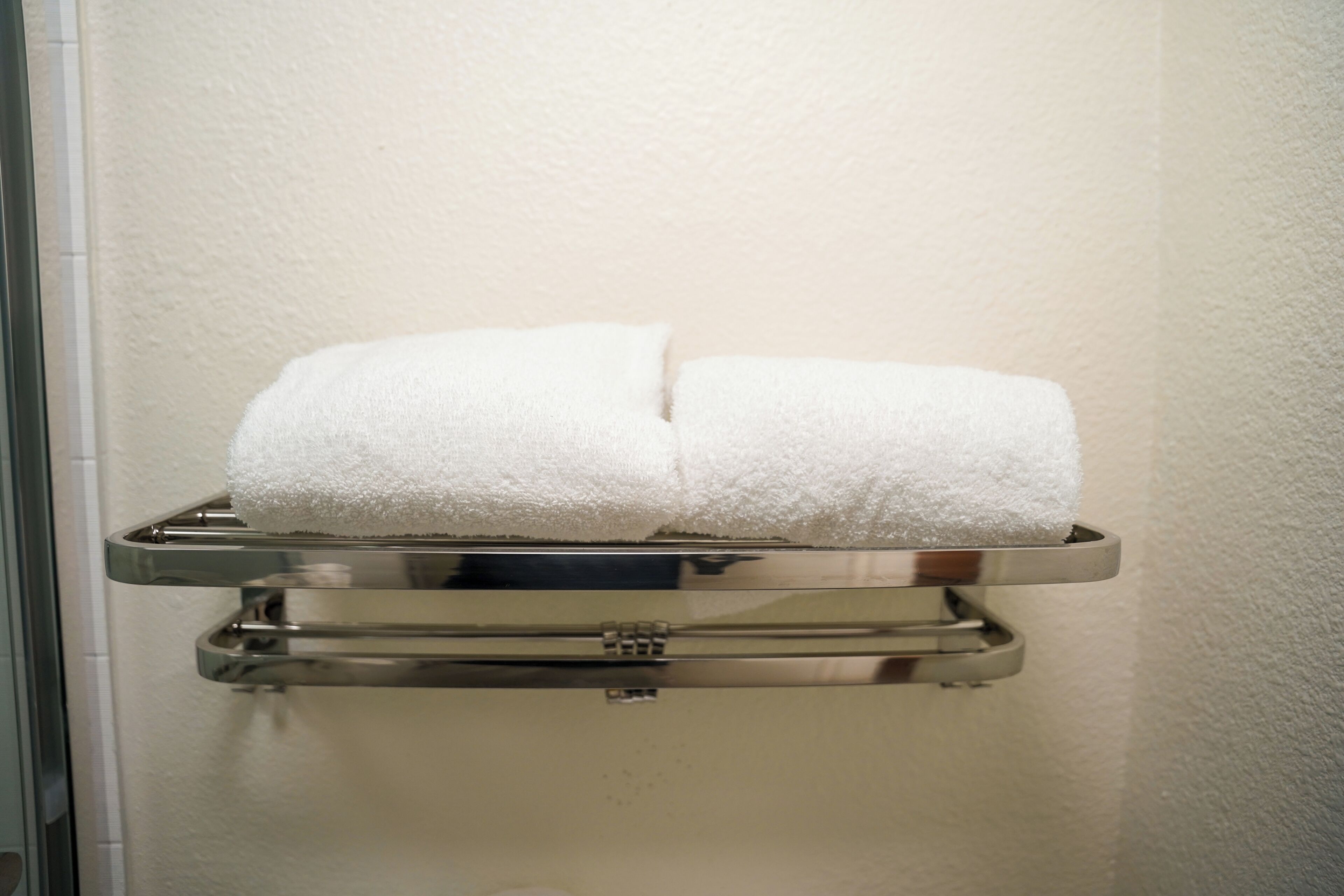 A towel rack with two white towels.
