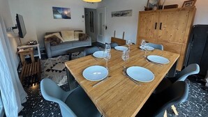 A dining area with a wooden table set for four, surrounded by modern chairs.
