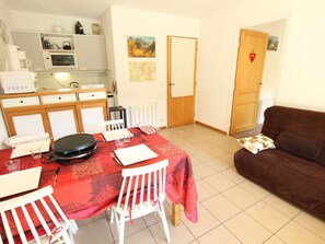 Un espace de vie compact comprenant un coin repas, une kitchenette et un canapé.