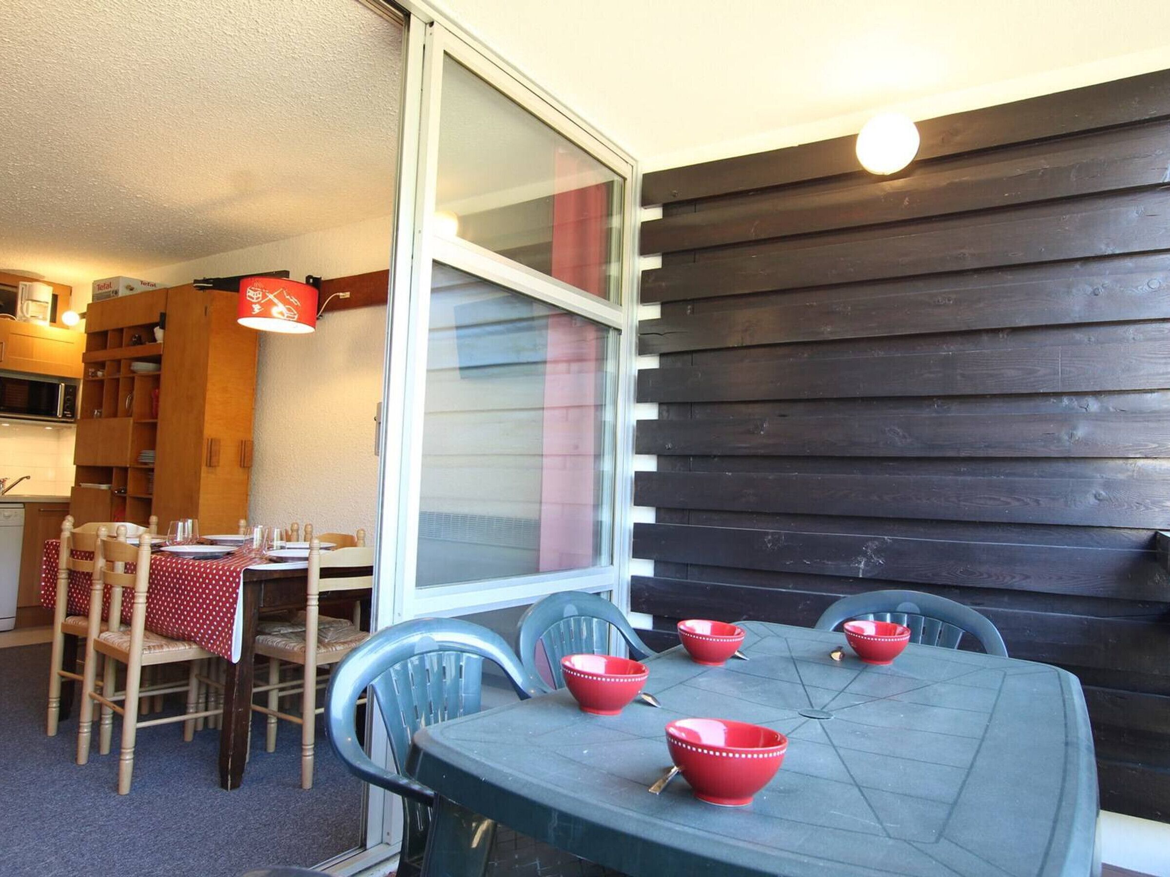 A dining area with a table set for four, surrounded by chairs.