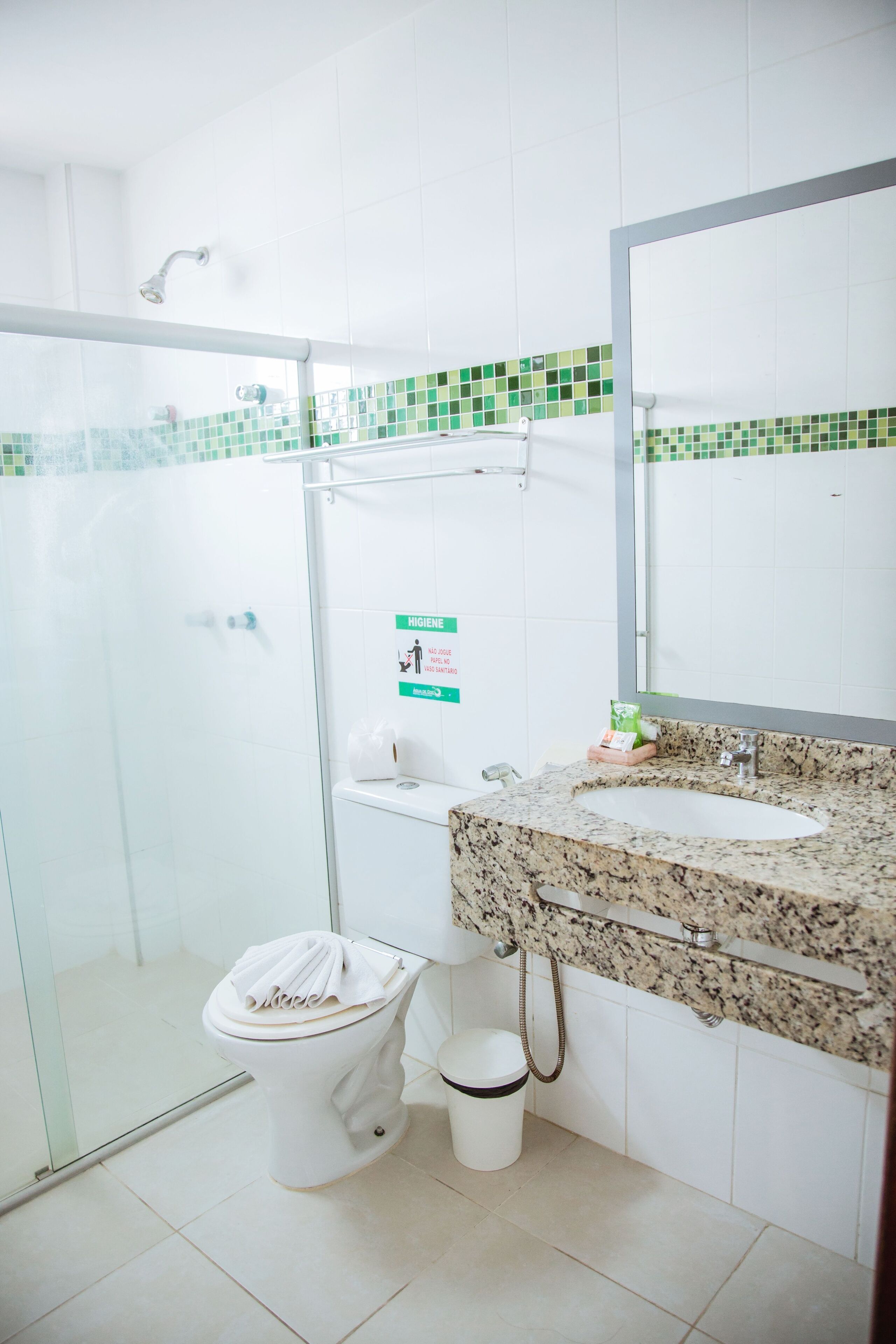 A bathroom with a toilet, sink, and shower.