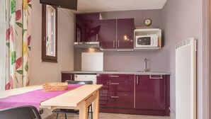 A compact kitchen with a microwave, stove, and cabinets.
