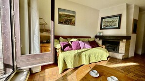 A cozy room with a bed, a fireplace, and a dining table with cups and saucers.
