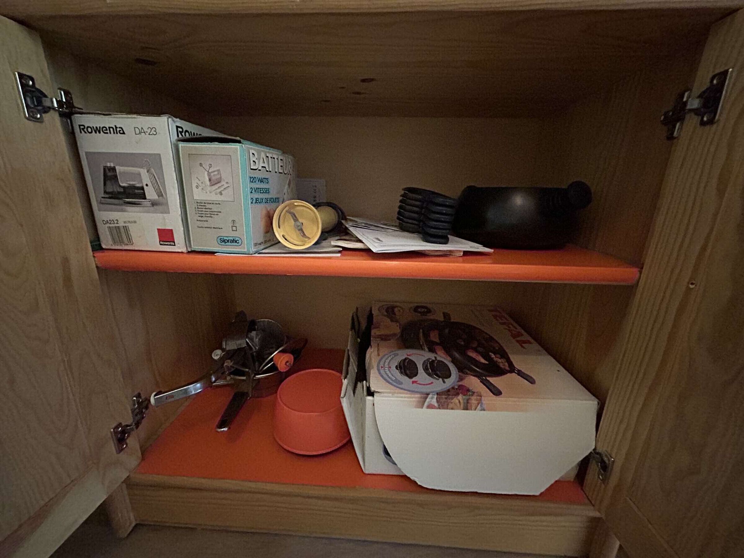 A wooden cabinet with two shelves containing various items.