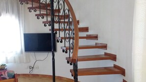 A spiral staircase with wooden steps and black metal railings in a room with tiled flooring. - Detached villa for 6 people located in Miami Playa (MIAMI PLAYA)