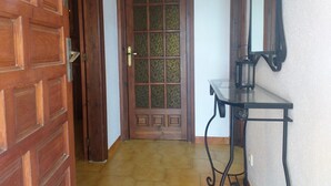 A wooden door with a glass panel, a small table with a lantern, and a tiled floor. - Detached villa for 6 people located in Miami Playa (MIAMI PLAYA)