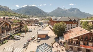 A town with buildings, a street, and mountains in the background.