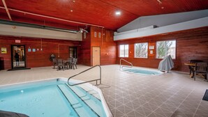 Une piscine intérieure divisée en deux zones distinctes, avec des murs en bois et un espace repas comprenant des chaises et une table.