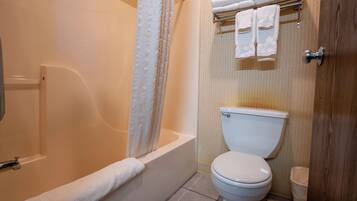 Un baño con bañera, inodoro y cortina de ducha.