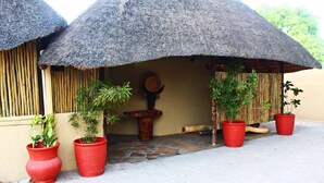 Un edificio con tejados de paja y grandes macetas con plantas.