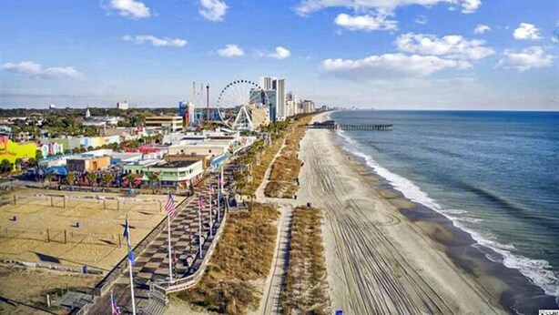 A coastal cityscape with a beach, a Ferris wheel, and a pier. - 3BR Condo in Myrtle Beach: Perfect for Families (MYRTLE BEACH)