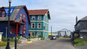 Una calle con casas coloridas, un coche estacionado y un farol.