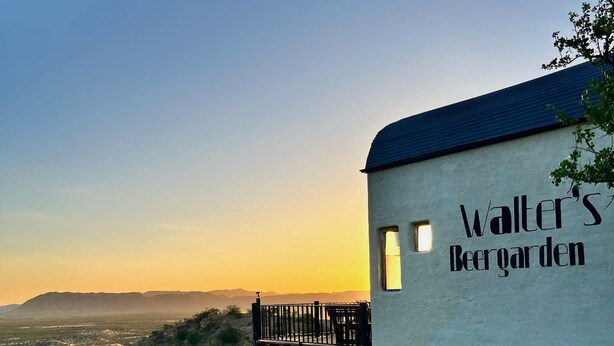 A building with a sign reading 'Walter's Beer Garden' and a patio with a table and chairs. - Ugab Terrace Lodge (Khorixas)