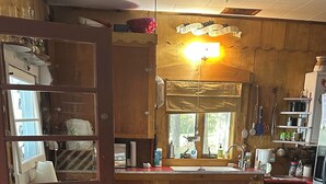 A kitchen with wooden cabinets, a refrigerator, and a window.