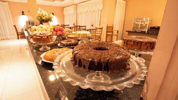 Buffet com diversos doces e frutas.