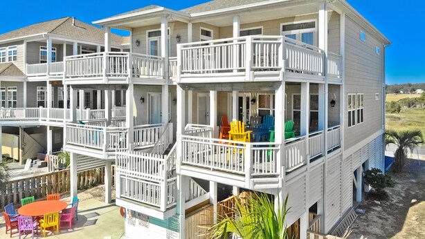 Un immeuble à plusieurs étages doté de balcons, d’un espace extérieur aménagé pour s’asseoir et offrant une vue dégagée sur le paysage environnant.