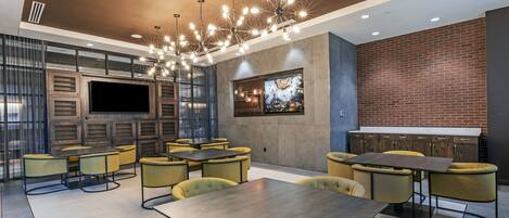 A modern lounge area with multiple seating options, a large flat-screen TV, and a decorative wall piece.