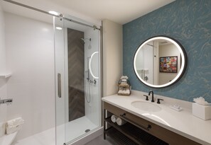 A modern bathroom with a glass-enclosed shower, a large mirror, and a white sink. - Hotel Indigo Tulsa DWTN-Entertainment Area by IHG (Tulsa)