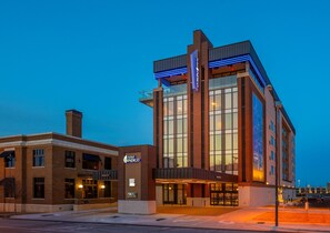 A hotel with a modern design, featuring a prominent glass facade and a rooftop terrace. - Hotel Indigo Tulsa DWTN-Entertainment Area by IHG (Tulsa)