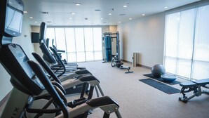 A gym with treadmills, a weight machine, and a squat rack. - Holiday Inn & Suites Houston NW - Vintage Park Area by IHG (Houston)
