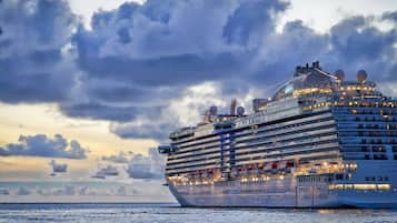 Un gran crucero con varias cubiertas y una estructura de proa destacada, navegando en aguas abiertas.