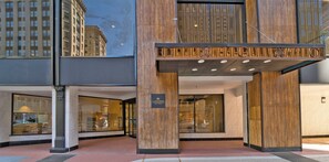 A hotel entrance with a modern design, featuring a large glass facade and a wooden panel accent. - Candlewood Suites Baltimore - Inner Harbor by IHG (Baltimore)