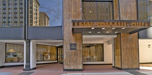 Ein Hotel mit Eingangsbereich, großflächiger Glasfassade und Holzverkleidung, sowie einer Beschilderung über der Tür.